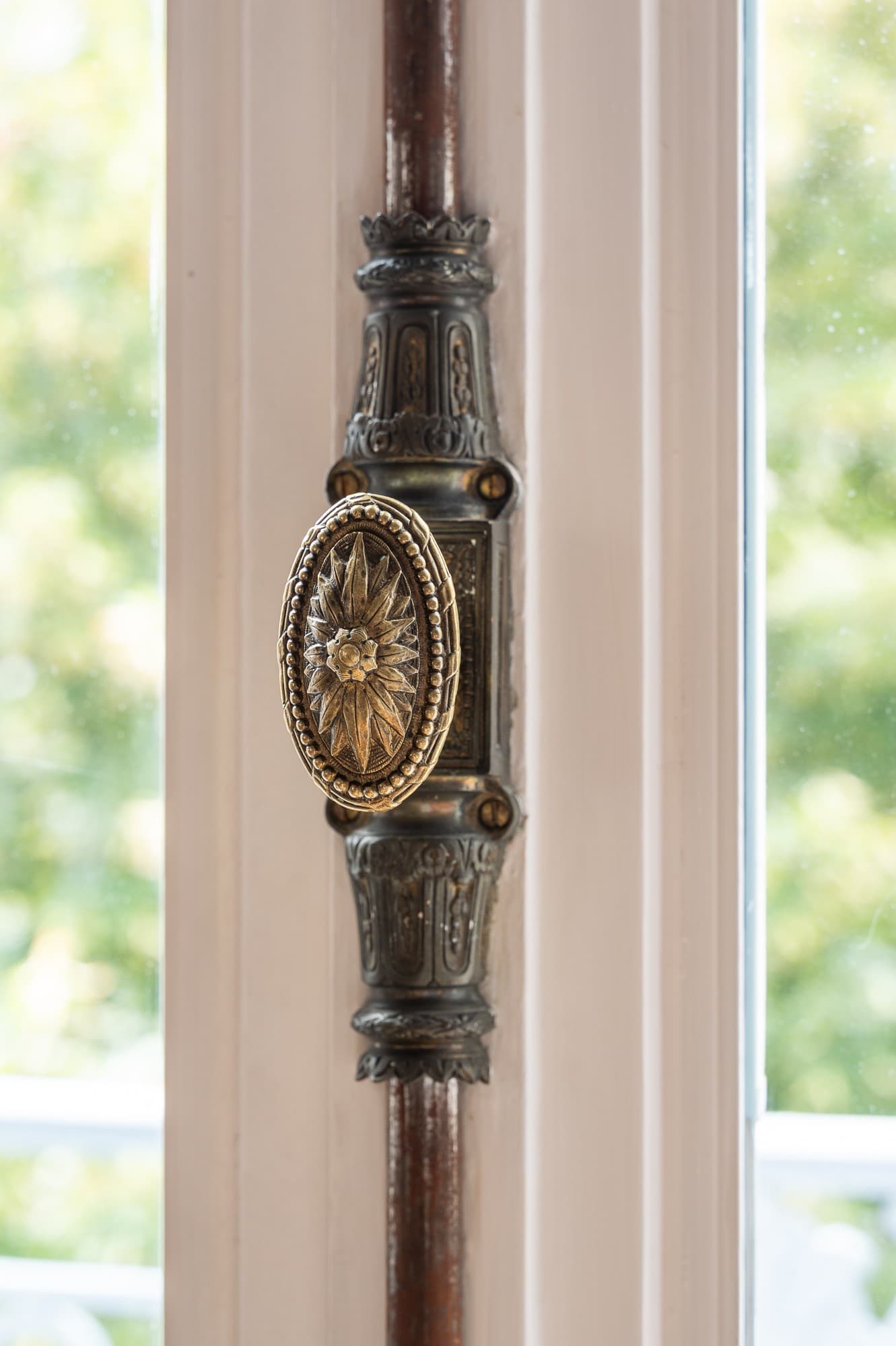 Poignée en bronze ouvragé d’une fenêtre d’appartement parisien